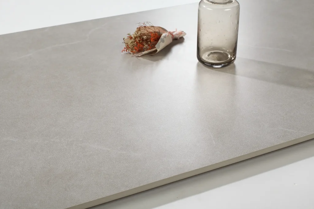 Närbild på microcement på bänkskiva i neutral ton med subtil struktur och enkla dekorationer.