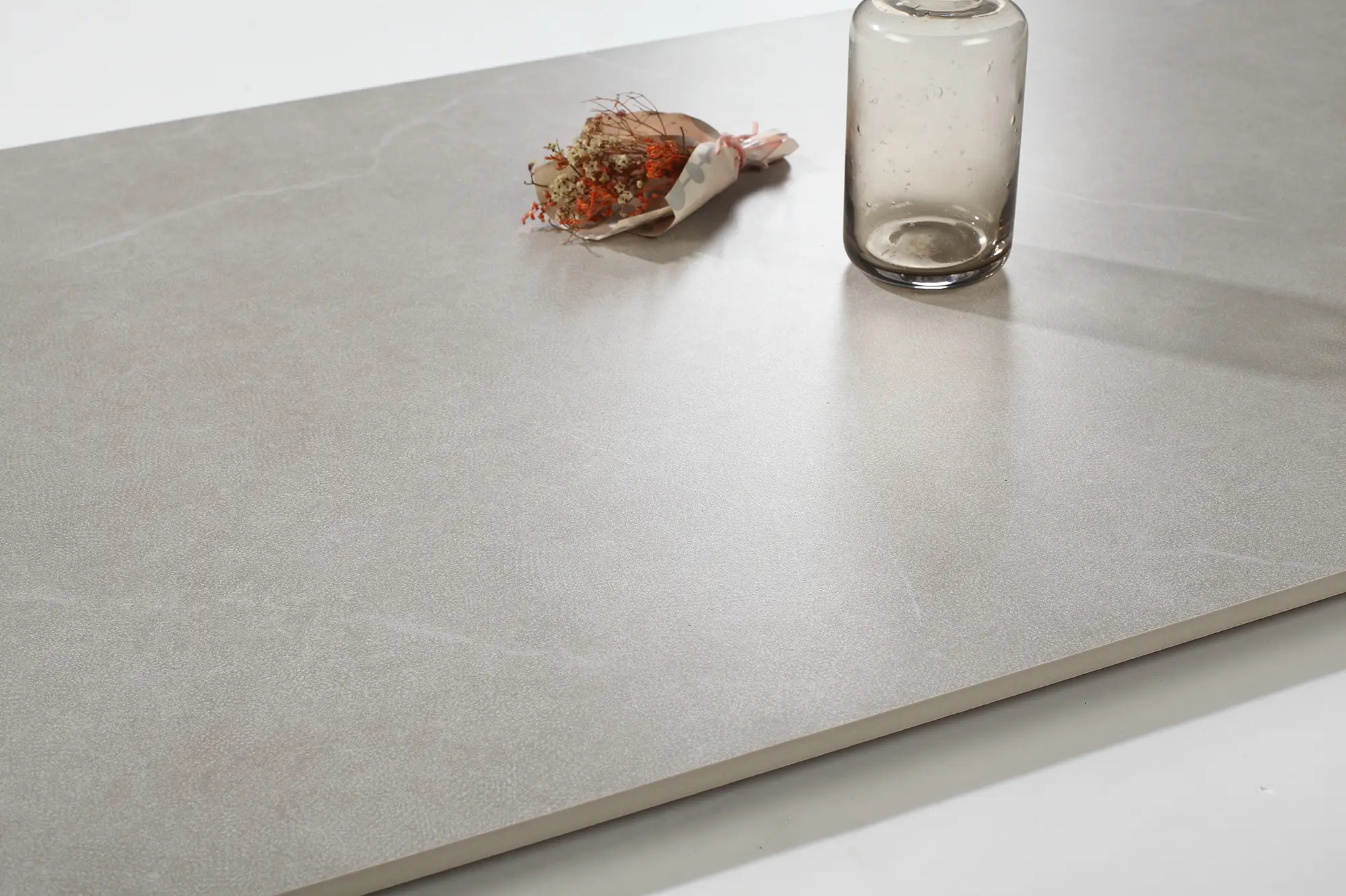 Närbild på microcement på bänkskiva i neutral ton med subtil struktur och enkla dekorationer.